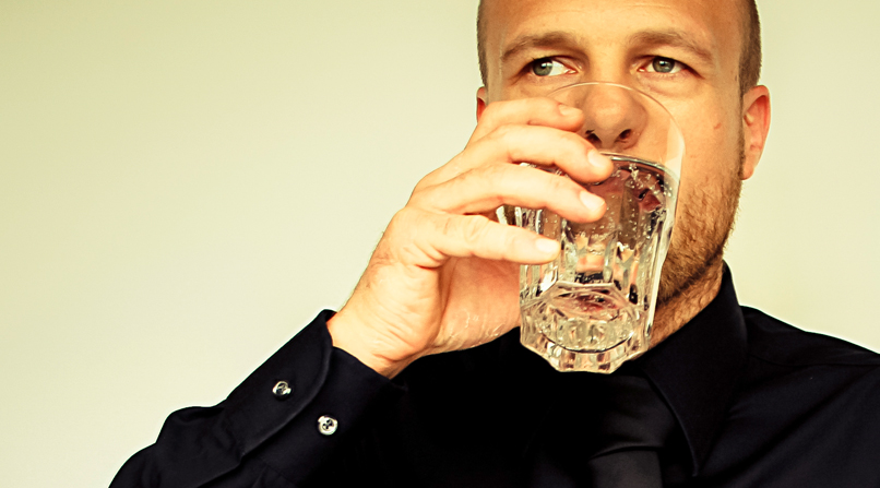 Man Drinking Water At Desk